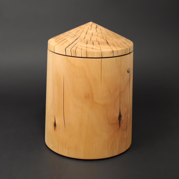 Holzurne in runder Obeliskform mit sich zur Oberseite verjüngendem Kegeldach. Holzart Kirschbaum.