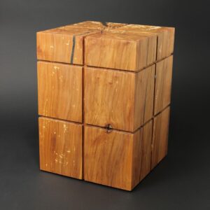 Minimalistisch und modern gestaltete Holzurne in kubischer Form. In der Holzart Kirschbaum aus einem Baumstamm gefertigt.