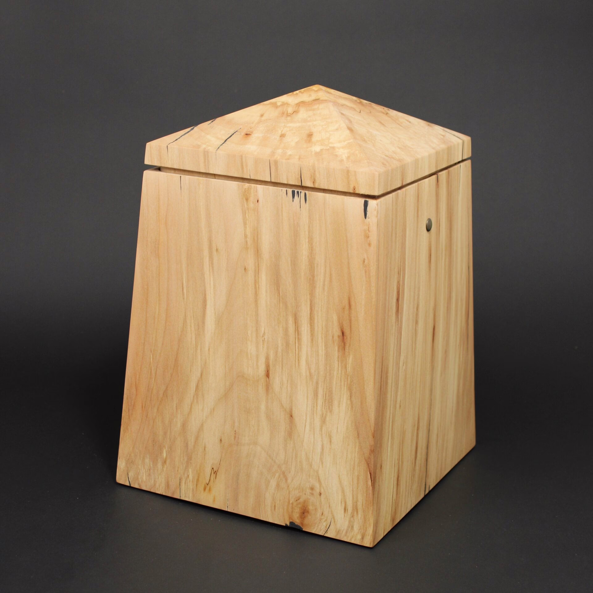 Holzurne in Obeliskform mit sich zur Oberseite verjüngender Form und Turmdach