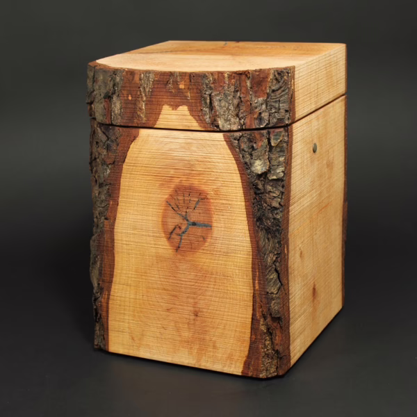 Puristisch gestaltete Holzurne aus Erle in Quaderform mit Waldkanten und sägerauer Oberfläche, ursprüngliche Naturholzstruktur