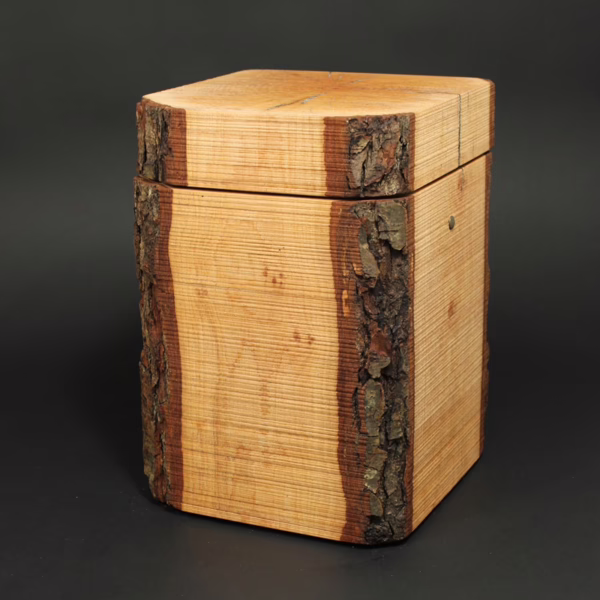 Puristisch gestaltete Holzurne aus Erle in Quaderform mit Waldkanten und sägerauer Oberfläche, ursprüngliche Naturholzstruktur
