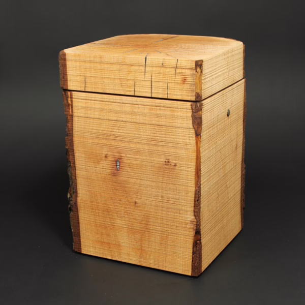 Puristisch gestaltete Holzurne aus Erle in Quaderform mit Waldkanten und sägerauer Oberfläche, ursprüngliche Naturholzstruktur